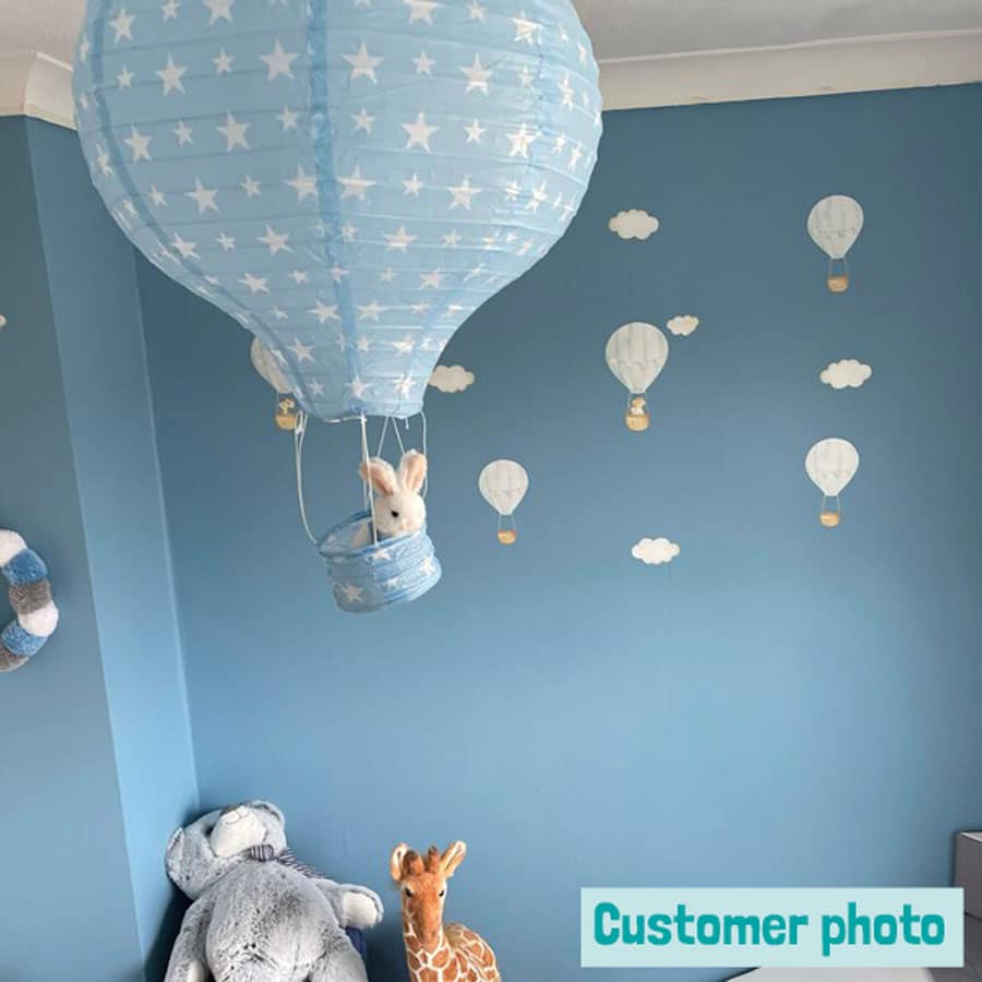 blue hot air balloons on a blue wall in a customers room with a hot air balloon lampshade