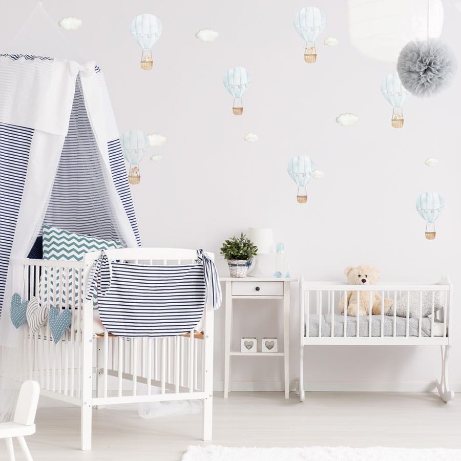 blue hot air balloon wall stickers on a child's nursery wall above a cot and changing mat