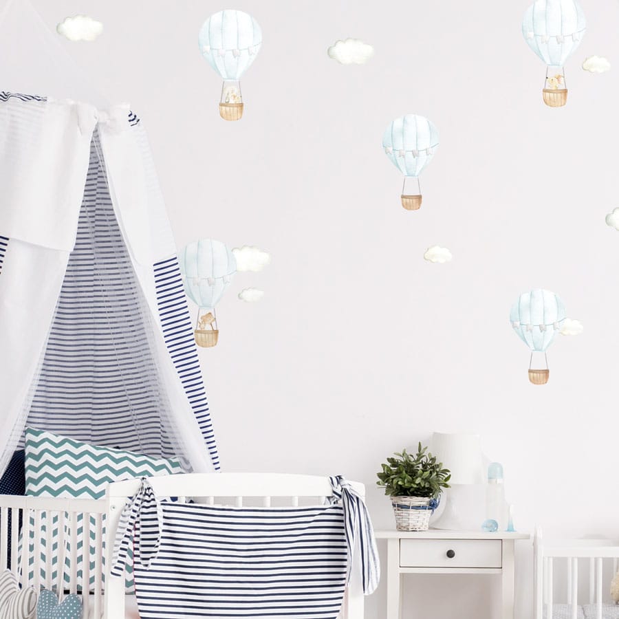 blue hot air balloon wall stickers on a child's nursery wall above a cot and changing mat