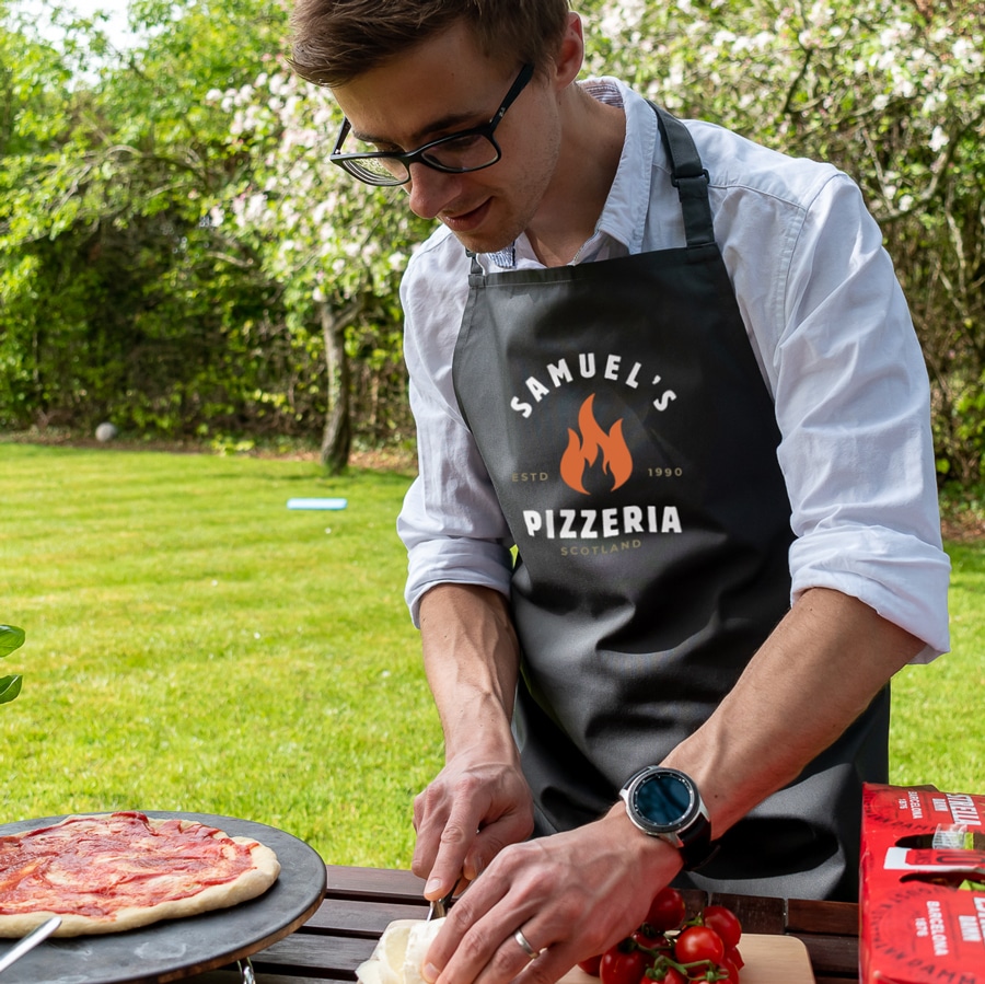Personalised Pizza Flame Apron in grey making a pizza